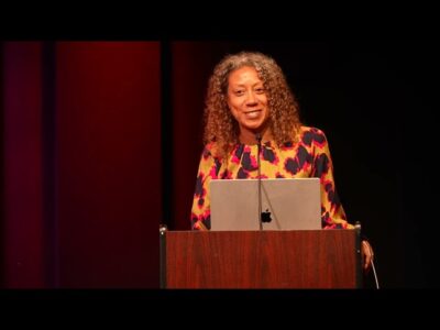Photo of a woman speaking at a podium.